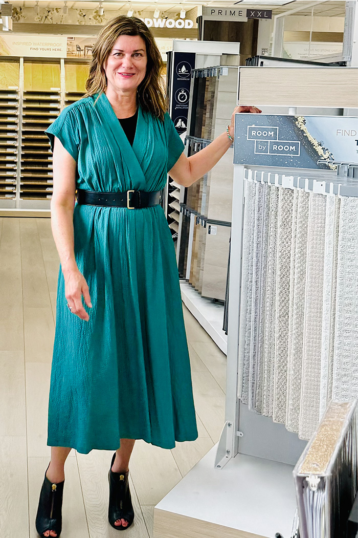 Photo of Lisa who works for Excelsior Paint and Design in Excelsior, Minnesota standing in front of carpet flooring display.